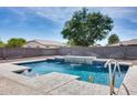 Sparkling backyard pool featuring a stone water feature, concrete surround, and a charming rubber ducky at 22616 S 194Th St, Queen Creek, AZ 85142