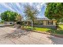 Classic ranch-style home with mature trees and meticulously landscaped front yard on a sunny day at 2938 N 18Th Ave, Phoenix, AZ 85015
