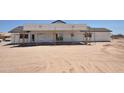Unfinished siding of a new home build shows window placement, with construction framework visible, in a desert setting at 1664 N 431St Ave, Tonopah, AZ 85354