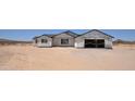A new home construction displays an unfinished exterior, with a garage and windows, in a desert location at 1664 N 431St Ave, Tonopah, AZ 85354