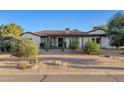 Inviting single story home with desert landscaping, blooming trees, and a paver driveway at 21315 E Marsh Rd, Queen Creek, AZ 85142