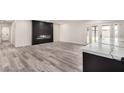 Bright living space with luxury vinyl plank flooring, fireplace accent wall and sliding glass doors to backyard at 3008 W Michigan Ave, Phoenix, AZ 85053