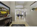 Hallway with tiled floors, decorative artwork and views into the living spaces at 45144 W Desert Garden Rd, Maricopa, AZ 85139