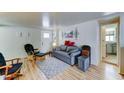 Charming living space with wood-look floors, a comfortable gray sofa, and a view of the front door and kitchen at 111 S Greenfield Rd # 400, Mesa, AZ 85206