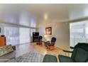 Cozy living area offering wood-look floors, comfortable chairs, a television, and easy access to the laundry room at 111 S Greenfield Rd # 400, Mesa, AZ 85206