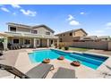 This backyard features a pool and spa, lounge chairs, a covered patio, and desert landscaping at 11225 E Sylvan Ave, Mesa, AZ 85212