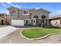 Two-story home with stucco exterior, stone accents, arched entryway, and manicured front yard at 11225 E Sylvan Ave, Mesa, AZ 85212