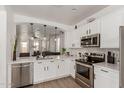 Bright, white kitchen with quartz countertops, stainless steel appliances, and an open view to the living area at 11979 W Pierce St, Avondale, AZ 85323