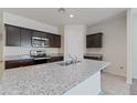 This kitchen features a large island with a sink, granite countertops, stainless appliances, and dark cabinets at 1314 W Kennedy Ave, Coolidge, AZ 85128