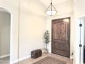 Inviting entryway with wood flooring, a striking wood door, and decorative accents create a warm welcome at 1421 W Rylie Ct, Queen Creek, AZ 85144