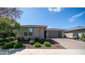 Inviting single-story home featuring stone accents and lush landscaping at 14637 W Wethersfield Rd, Surprise, AZ 85379