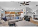 Open-concept living room with a comfortable sectional sofa, ceiling fan, and seamless flow to the kitchen at 17152 W Watkins St, Goodyear, AZ 85338