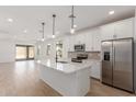 Open kitchen boasts an island, stainless appliances, and sleek white cabinets at 18498 E Dario Rd, Gold Canyon, AZ 85118