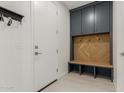 A functional mudroom features a built-in bench and storage cabinet at 21341 S 227Th Way, Queen Creek, AZ 85142