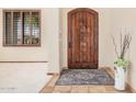Elegant entryway featuring a wood door, travertine flooring, and a window with shutters at 21615 E Pegasus Pkwy, Queen Creek, AZ 85142