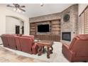 Inviting living room with a brick accent wall, built-in shelves, fireplace, and plush seating at 21615 E Pegasus Pkwy, Queen Creek, AZ 85142