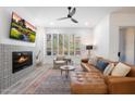 Cozy living room with a tile fireplace, plantation shutters and modern ceiling fan at 28990 N White Feather Ln # 121, Scottsdale, AZ 85262