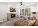 Comfortable living room with tile fireplace, large window, ceiling fan and leather couch at 28990 N White Feather Ln # 121, Scottsdale, AZ 85262