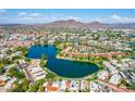 Scenic aerial shot featuring a tranquil lake, red tile roofs, and distant mountain views at 3029 W Sierra St, Phoenix, AZ 85029