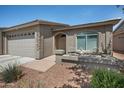 Inviting single-story home featuring a three-car garage, desert landscaping, and comfortable front porch seating at 3117 S Signal Butte Rd # 484, Mesa, AZ 85212