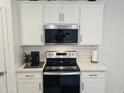 Clean kitchen has white cabinets, subway tile backsplash, and stainless steel appliances at 36354 W San Clemente Ave, Maricopa, AZ 85138