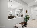 Inviting entryway with neutral walls, stylish decor, bench with throw, and tile floors leading to the dining room at 4115 S 180Th Dr, Goodyear, AZ 85338