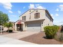 Inviting two-story home with a desert landscaped yard, a two-car garage and American Flag on the porch at 4115 S 180Th Dr, Goodyear, AZ 85338