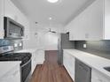 Modern kitchen with gray backsplash, stainless appliances and quartz countertops at 4337 E Wilshire Dr, Phoenix, AZ 85008