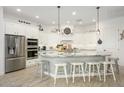 Bright, modern kitchen with white cabinets, stainless steel appliances, large island, and stylish pendant lighting at 4450 S Frequency --, Mesa, AZ 85212