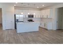 Bright kitchen features white cabinets, stainless steel appliances, a large island, and tile backsplash at 48171 N La Soledad --, Gold Canyon, AZ 85118