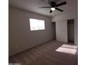 Bright bedroom with neutral carpet, ceiling fan, and large window, creating a relaxing and comfortable atmosphere at 720 S Dobson Rd # 24, Mesa, AZ 85202