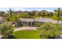 Stunning home featuring a circular driveway, vibrant flower bed, and lush landscaping with mountain views in the background at 7272 N 71St St, Paradise Valley, AZ 85253