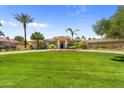 Inviting home boasts a lush green lawn, circular driveway, and mature palm trees enhancing the curb appeal at 7272 N 71St St, Paradise Valley, AZ 85253