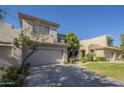 Two-story stucco home with a well-manicured lawn and a two-car garage on a sunny day at 7296 E San Alfredo Dr, Scottsdale, AZ 85258