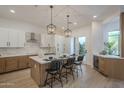 Modern kitchen with stainless steel appliances, a large island, and stylish pendant lights at 7296 E San Alfredo Dr, Scottsdale, AZ 85258