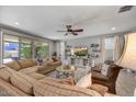 Cozy living room with large couch, ceiling fan, TV, and sliding glass doors at 7407 E Portobello Ave, Mesa, AZ 85212