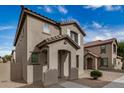 Inviting two-story home with a tiled roof, arched entryway, and neutral stucco in a well-maintained community at 829 E Agua Fria Ln, Avondale, AZ 85323