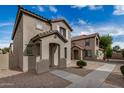 An inviting two-story home with an arched entryway, stucco facade, and tiled roof in a well-kept neighborhood at 829 E Agua Fria Ln, Avondale, AZ 85323