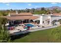 Aerial view of an estate featuring a pool, outdoor seating, and lush landscaping with mountain views at 8515 E Sutton Dr, Scottsdale, AZ 85260