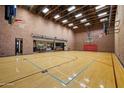 Spacious indoor basketball court with hardwood flooring and brick walls; attached to an entertainment room at 8515 E Sutton Dr, Scottsdale, AZ 85260
