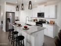 Bright kitchen with white cabinets, granite countertops, and stainless steel appliances at 8950 W Albeniz Pl, Tolleson, AZ 85353