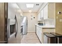 Bright kitchen features stainless steel appliances, sleek white cabinets, and contemporary lighting at 9021 W Elm St # 7, Phoenix, AZ 85037