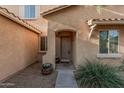 Close up of the front entrance featuring a neutral color palette, small entryway, and desert landscaping at 9234 W Hedge Hog Pl, Peoria, AZ 85383