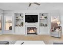 Spacious living room with a fireplace, built-in shelving, and plenty of natural light at 12935 E Mercer Ln, Scottsdale, AZ 85259