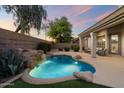 Backyard oasis featuring a rock waterfall, lush landscaping, and a cozy seating area for outdoor relaxation at 14424 N 64Th Pl, Scottsdale, AZ 85254