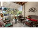 Cozy covered patio area with comfortable wicker furniture, decorative accents, and a view of the garden at 16307 E Arrow Dr # 104, Fountain Hills, AZ 85268