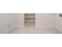 Spacious laundry room with tiled floor, ample shelving, and hookups for a washer and dryer at 21278 N 272Nd Ave, Buckeye, AZ 85396