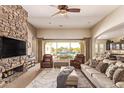 Spacious living room featuring a stone fireplace and sliding doors to the backyard pool at 21623 S 223Rd Pl, Queen Creek, AZ 85142