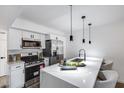 Modern kitchen features stainless appliances, sleek white cabinetry, and an island with a waterfall countertop at 3416 N 44Th St # 51, Phoenix, AZ 85018