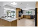 Bright, open kitchen featuring wood cabinetry, modern appliances, and a view to the backyard and pool at 8019 E Del Timbre Dr, Scottsdale, AZ 85258